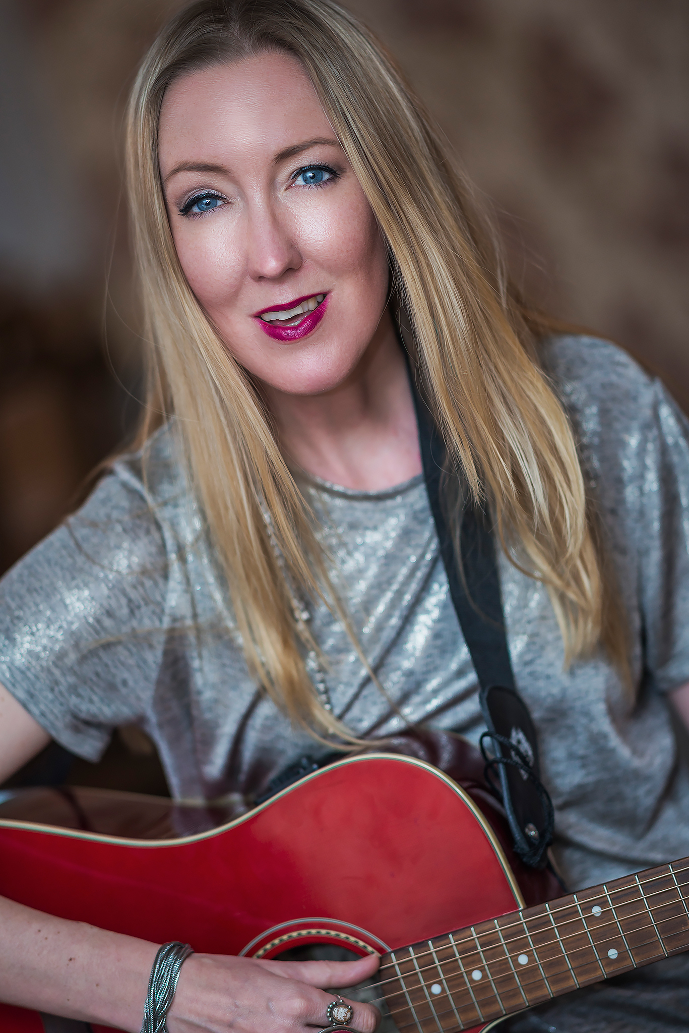 Premiär på Lilla Styrbjörn Gästhamnen i Södertälje. Kajsa Larsson håller en röd gitarr i handen, ler in i kameran